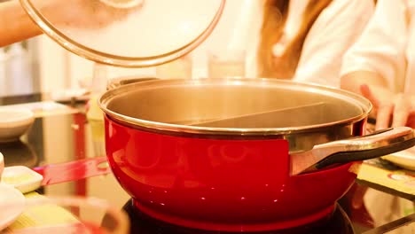 preparando el sukiyaki en una olla roja