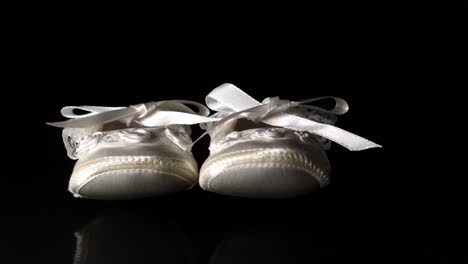 baby shoes falling and bouncing on black background