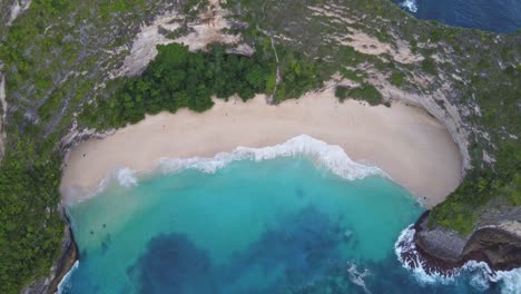 Luftaufnahme-Des-Kelingking-Strandes-Auf-Der-Insel-Nusa-Penida-Auf-Bali-Aus-Der-Vogelperspektive-Und-Wellen,-Die-An-Der-Weißen-Sandküste-Mit-Surrealem-Türkisblauem-Wasser-Krachen