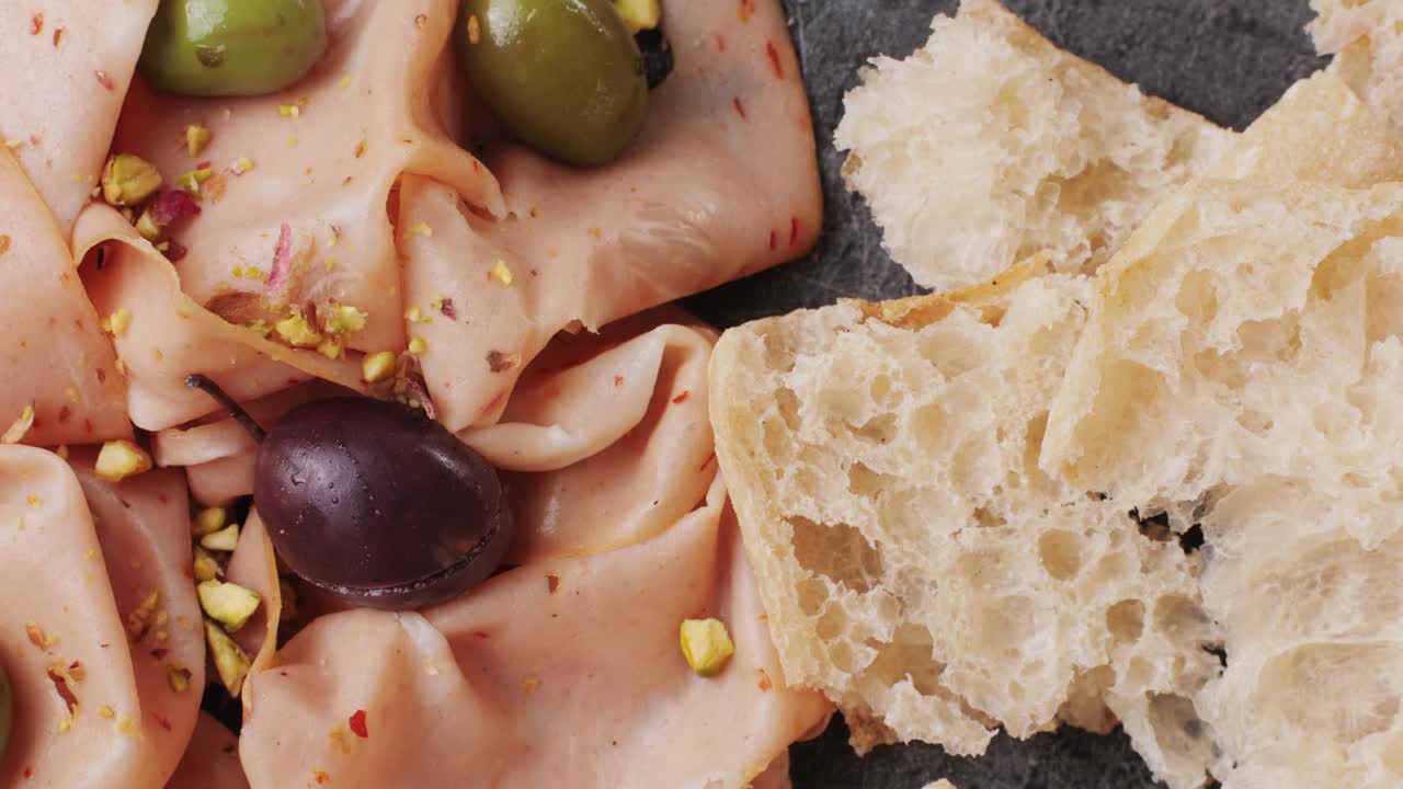 Ham italian mordatella, man Slices Of Traditional Italian antipasti mortadella sausage on a wooden cutting board, close up macro of chicken or turkey jamon, fat breakfast dish.