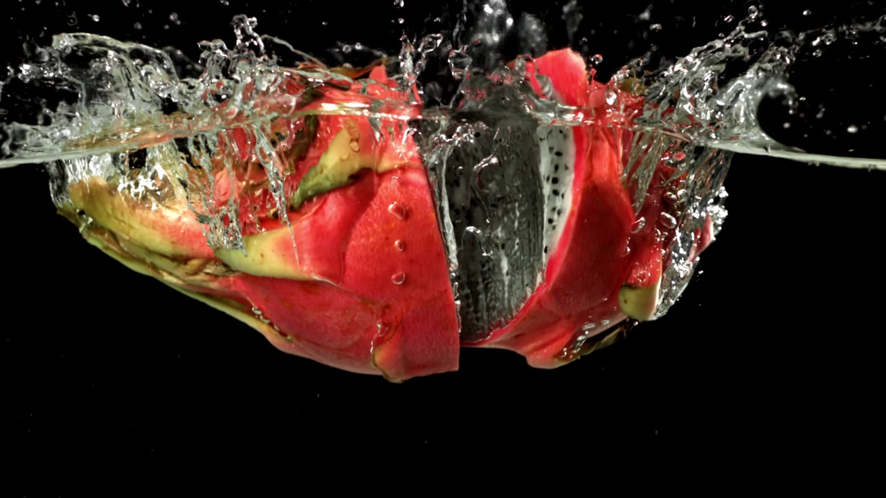 Halved Dragon Fruit Splashing into Water in Slow Motion