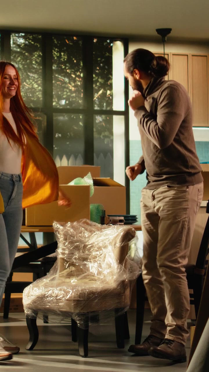Vertical Video Happy couple dancing in new house and having fun together