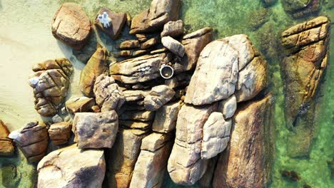 beautiful cliffs caved by clear water of turquoise sea, plunged on white sand of exotic beach in koh tao, thailand, aerial view