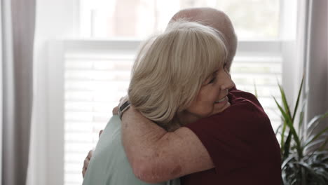 elderly couple dancing and embracing indoors