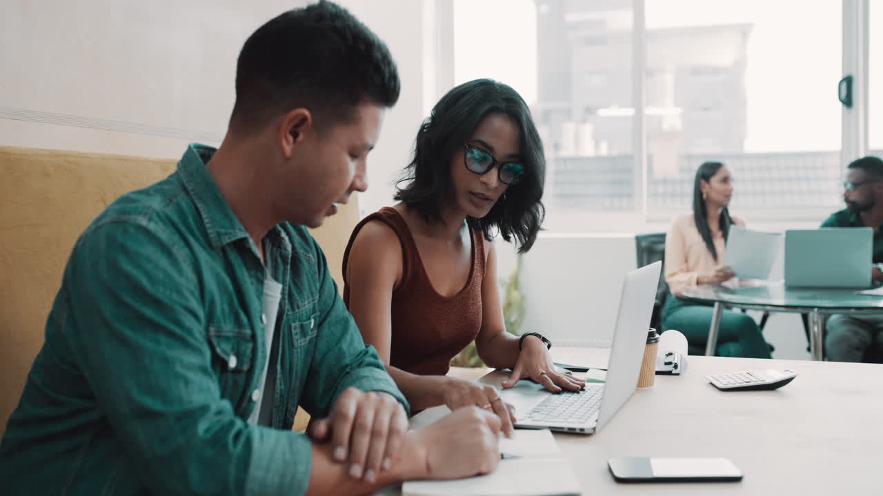 Two young business people sitting in the office