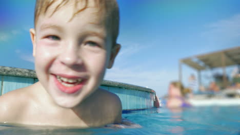 niño feliz en la piscina salpicando agua