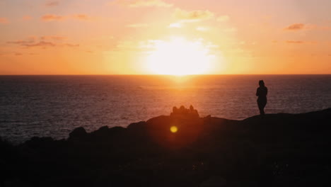 epic wide shot showing group of people relaxing in front of pretty sunset,slow motion