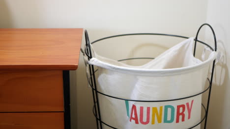 cloths being tossed into a laundry hamper