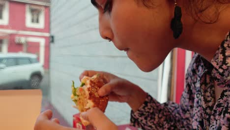 close-up of young indian woman enjoying junk food delight