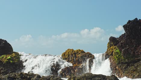 foamy ocean water flowing over rocky barrier, low angle view