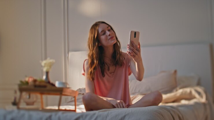 девушка записывает домашнее видео в солнечное утро. улыбающийся подросток разговаривает по видео.