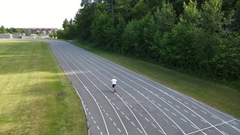 Drone-following-young-male-skateboarder-along-a-running