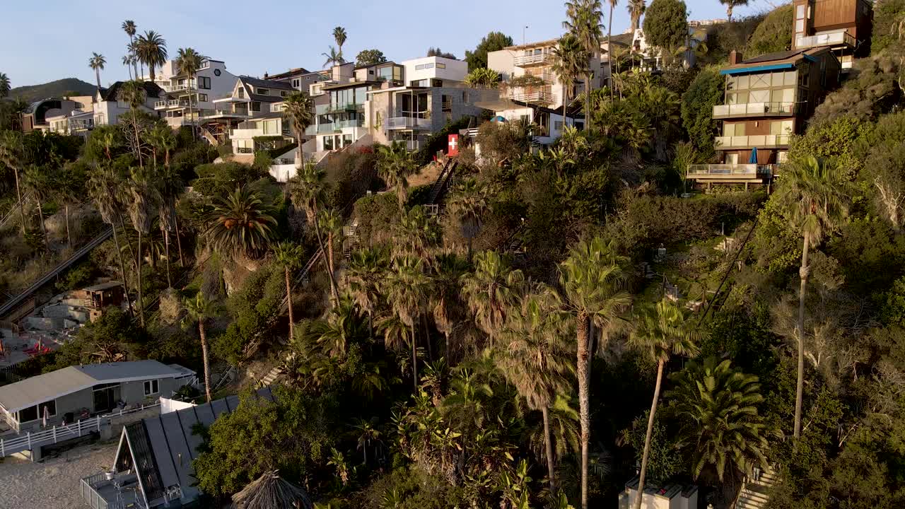 toma aérea de drones de bienes raíces costeros entre palmeras en el condado de orange - california