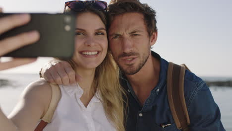 happy couple having fun taking selfie using phone making faces enjoying sunny beach vacation