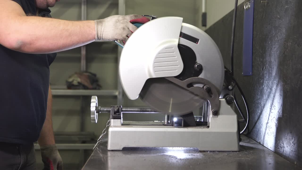 aserrar metal por máquina en el taller.