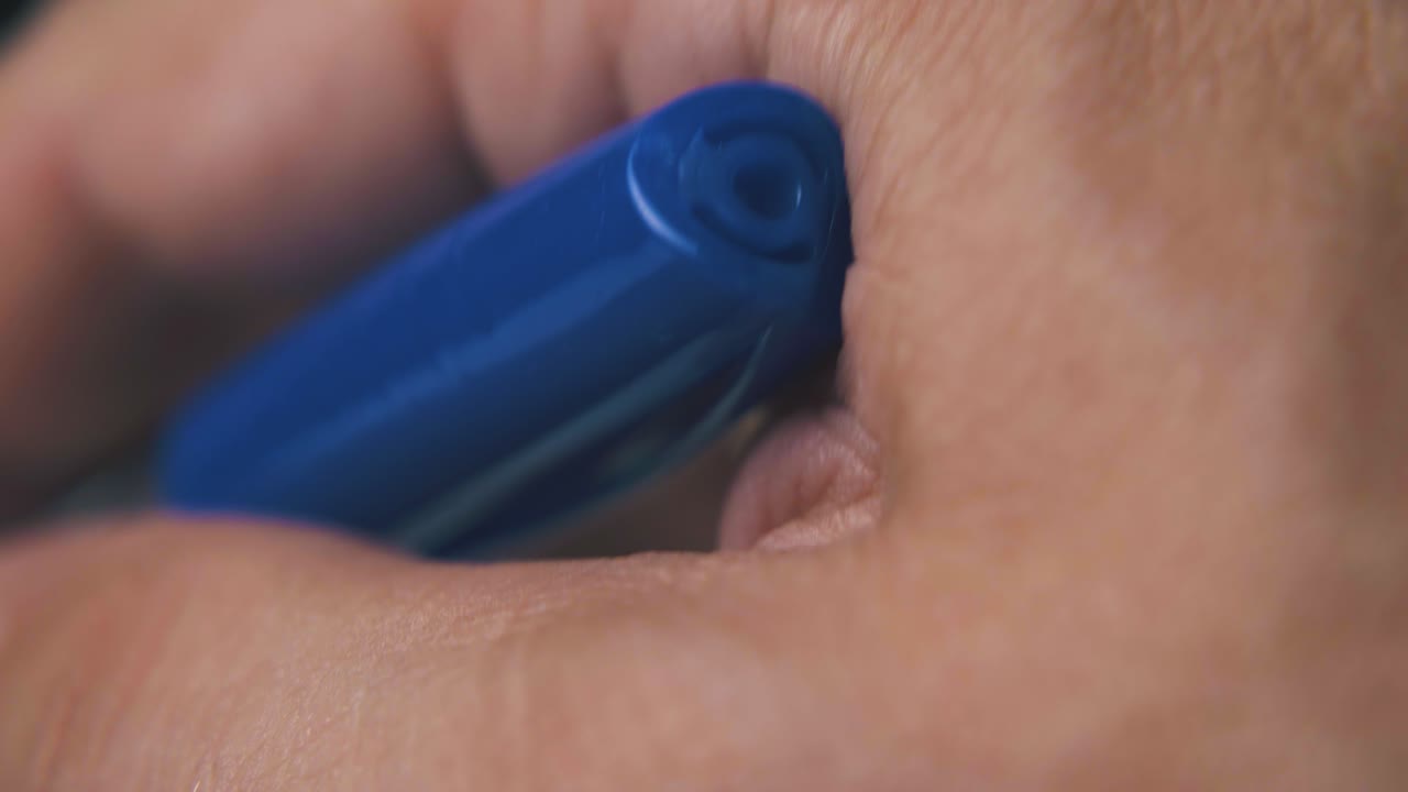 hand of mature man holds new ball pen on dark background
