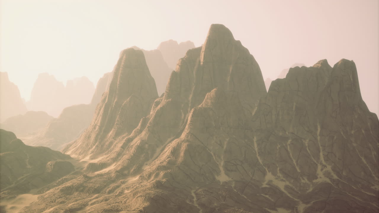 Vast desert landscape featuring majestic mountains under soft sunrise light