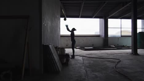 african american woman exercising with medicine ball in an empty urban building