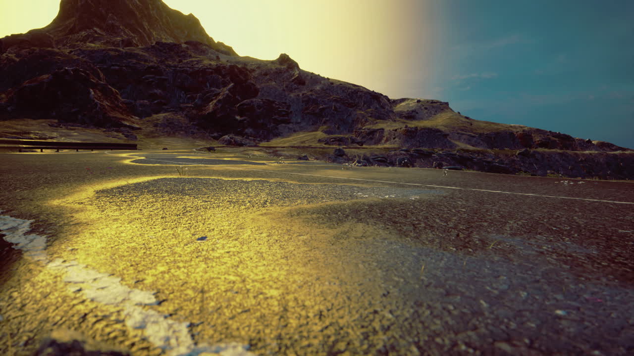 Mountain road winding through a dramatic landscape at sunset