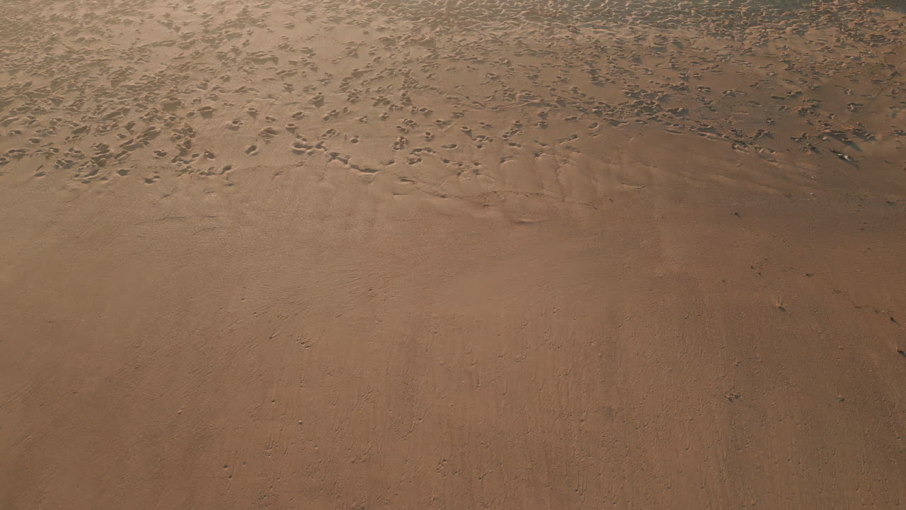 Sunny sandy beach texture aerial view. Sunlight reflecting shiny dunes landscape