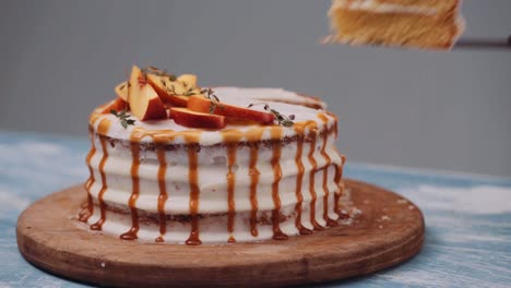 cutting a slice of cake with peach and caramel icing using knife