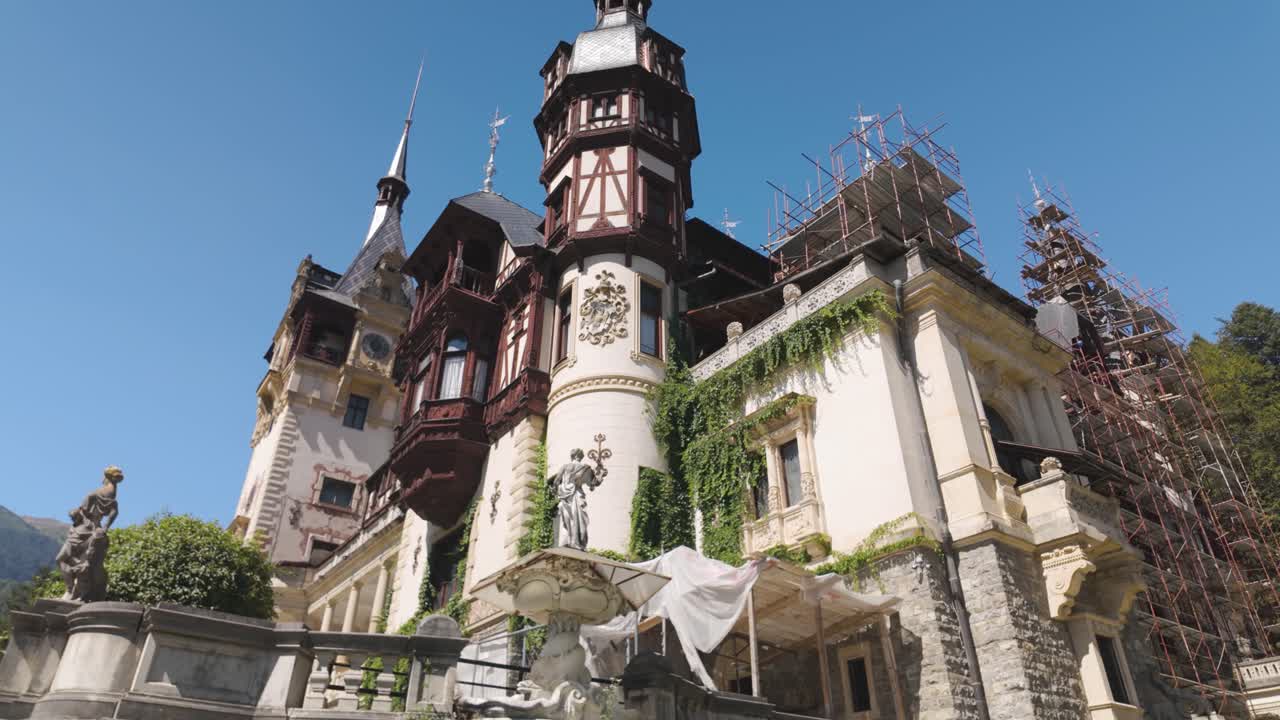 Peleș Castle in Sinaia showing sections of the historic facade under renovation and partially covered for restoration work