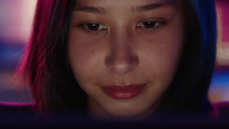 close up portrait young asian woman using tablet computer working late browsing online looking at screen enjoying internet connection