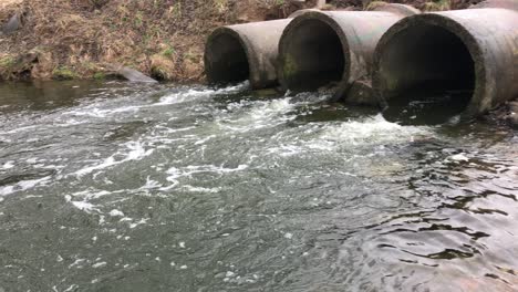 streams of water flow through concrete sewers. polluted body of water in the park