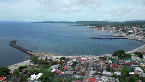 aerial, rising, drone view of peaceful waterfront town and port in virac, catanduanes, philippines