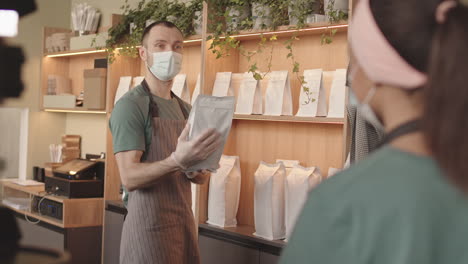 two waiters discussing pack of coffee in restaurant