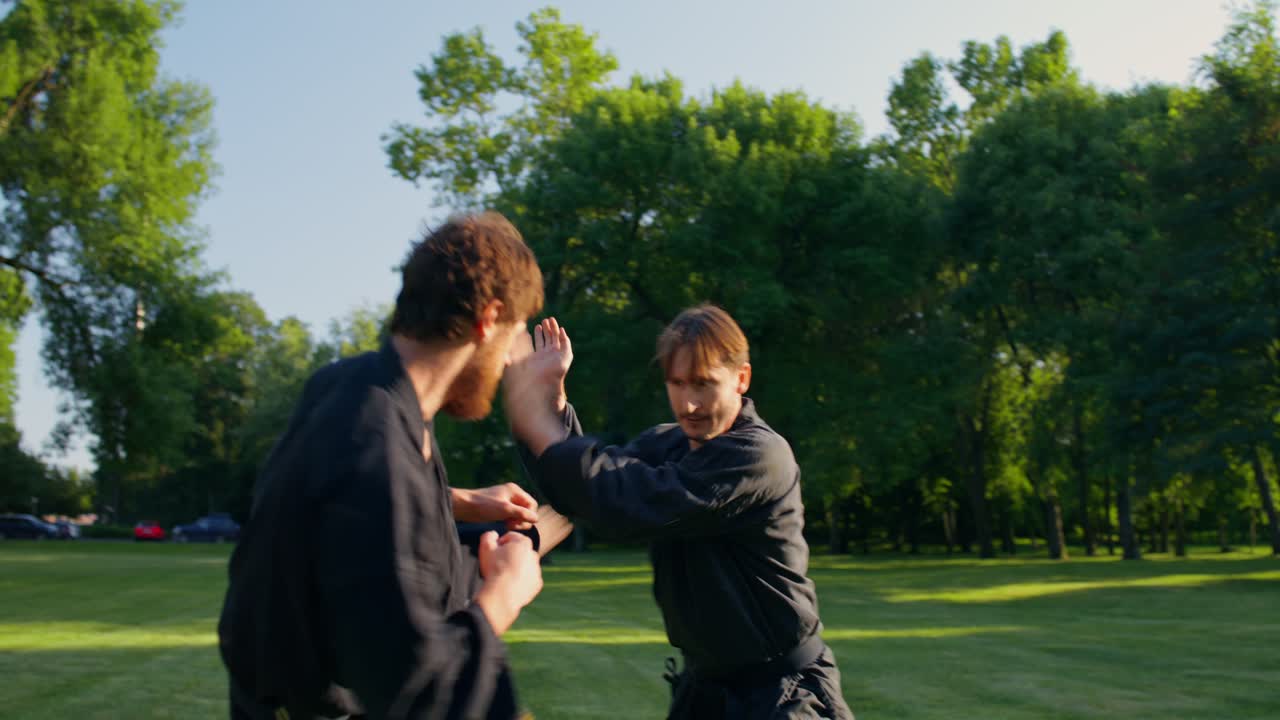 Two Men Practicing Martial Arts in a Park