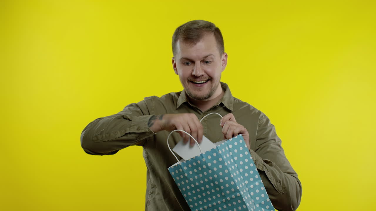 hombre feliz mostrando la inscripción del viernes negro de la bolsa de compras, sonriendo, regocijándose descuento