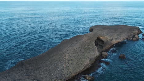 rising aerial of stone formation at kukuihoolua island by oahu, hawaii