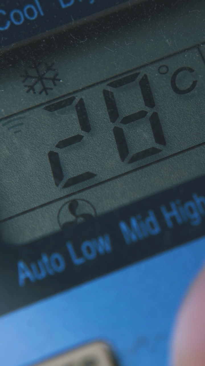man installs highest temperature pressing buttons on air conditioner remote control extreme close view