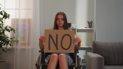 serious woman shows poster with word no looking in camera