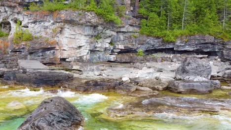olas chocando contra las paredes de piedra de granito en la isla flowerpot en la bahía de georgia, ontario, canadá