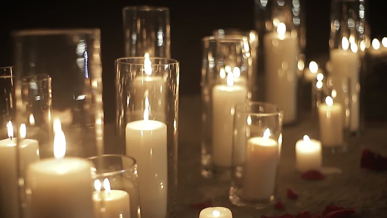 File di candele che bruciano in uno spazio buio