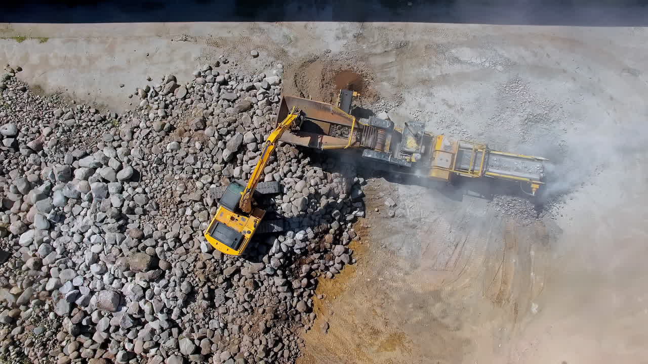 toma aérea de maquinaria pesada que mueve grandes rocas y crea grava