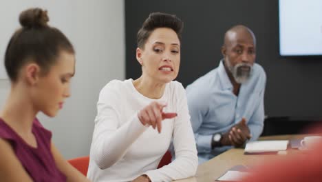 Happy-diverse-business-people-discussing-work-during-meeting-at-office