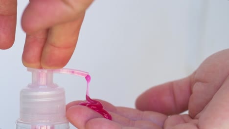 pouring red liquid soap in the hands