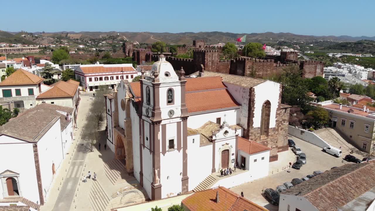 catedral de silves desde el portal principal dominado por el castillo en el fondo en algarve - toma de órbita aérea de ángulo bajo