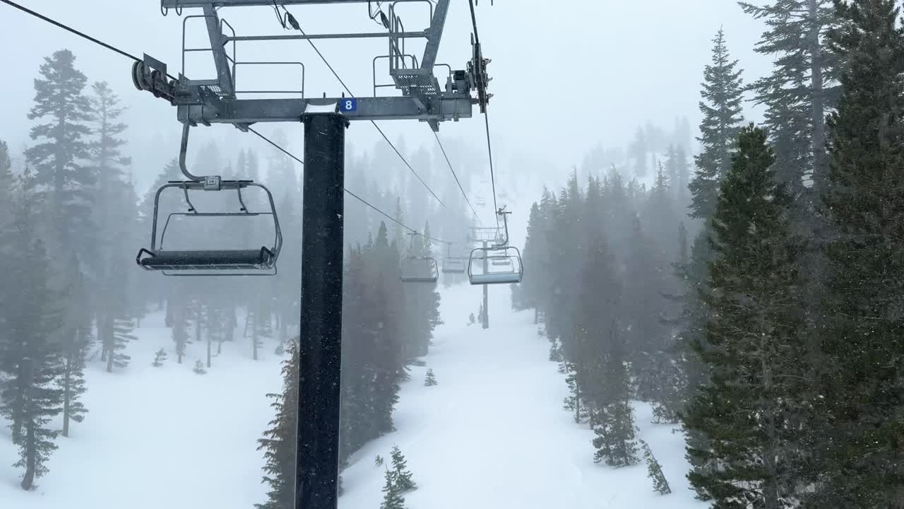 Chairlift Mammoth mountain ski resort The Hemlocks main lodge winter feet of snow dumping snowy blizzard on ski snowboard trail run California cloudy foggy backcountry forest follow motion