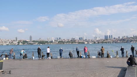 fishermen on a pier with a city skyline in the background