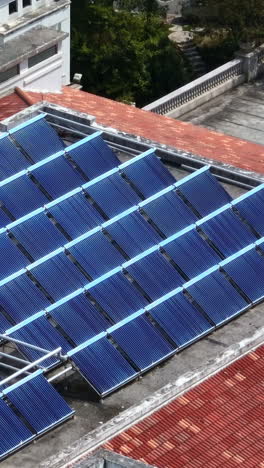 vertical drone shot of reflecting solar panels on a roof in china, sunny day