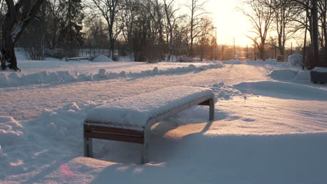snow covered bench in the park