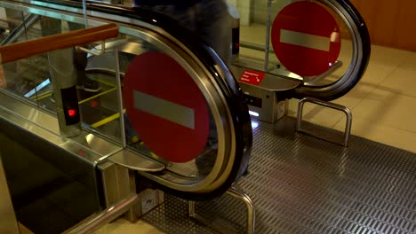 people with suitcases leave the escalator at the airport
