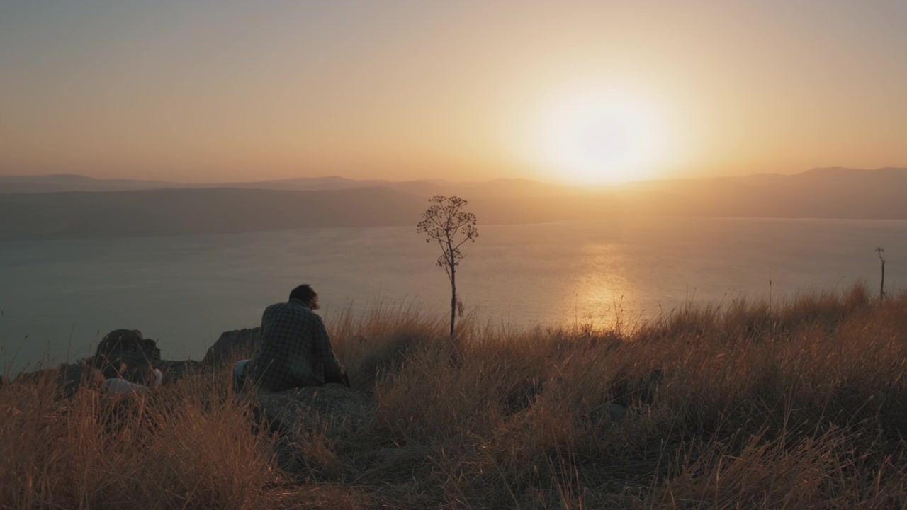Man sitting down on the edge of a cliff