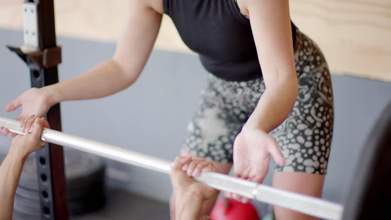 체육관 벤치에서 웨이트 트레이닝을 하고, 슬로우 모션으로 바벨을 누르고 있습니다.