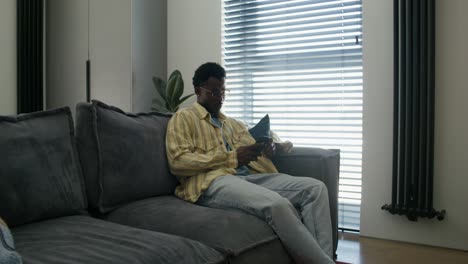 man using a smartphone on a couch in a modern living room