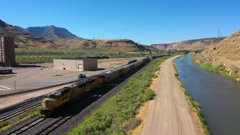 train moving slowly in a mountainous landscape on the union pacific railway - aerial view